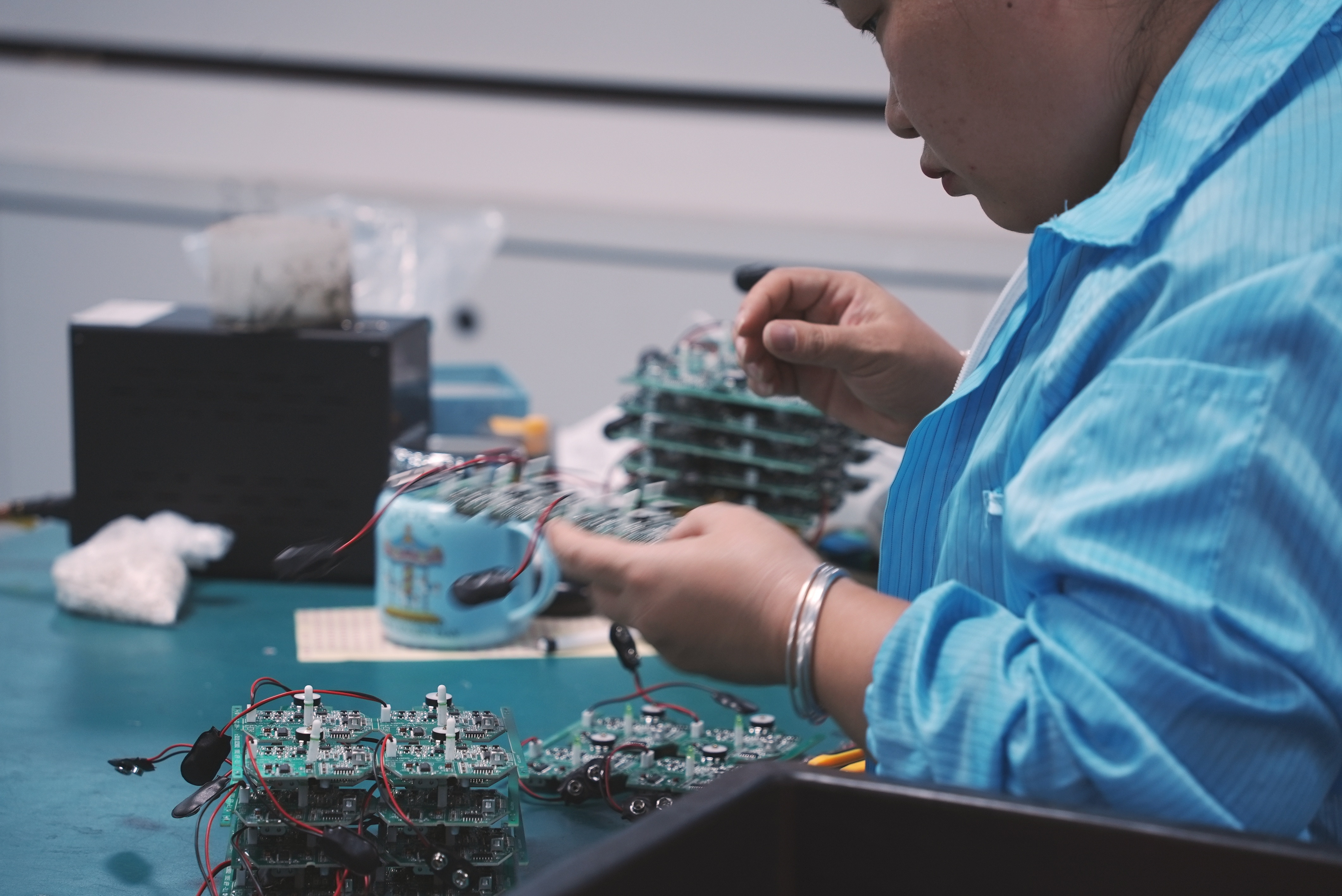 production quality management Guangdong technician inspecting plastic enclosure and PCBA circuit board dimension tolerance